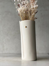 Load image into Gallery viewer, Close-up of a tall white hand-built porcelain vase with a small gold heart motif, styled with dried flowers on a light background.