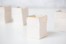 Load image into Gallery viewer, A white handmade porcelain Boxeen tealight holder with a gold lustre rim, shown in a close-up on a white surface.