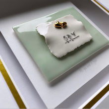 Load image into Gallery viewer, Close up of All You Need Is Love handmade porcelain wall piece in a white box frame with three birds on a wire and three hearts on a sea green ceramic tile. 
