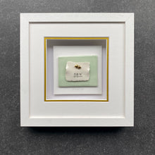 Load image into Gallery viewer, All You Need Is Love handmade porcelain wall piece in a white box frame with three birds on a wire and two hearts on a sea green ceramic tile. 

