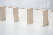 Load image into Gallery viewer, Group of white handmade porcelain Boxeen tealight holders with gold lustre rims, arranged on a white surface.
